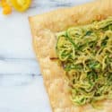 zucchini tart on counter with tomatoes by it