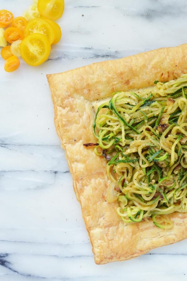 zucchini tart on counter with tomatoes by it