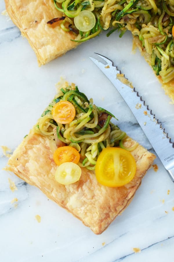 zucchini tart on marble cutting board with knife by it