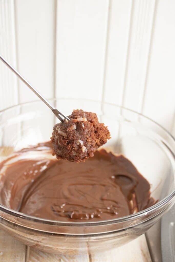 dipping cake ball in chocolate