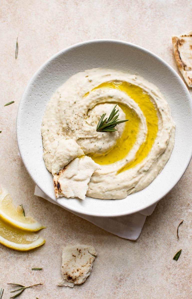 white bean dip in a white bowl on plate 