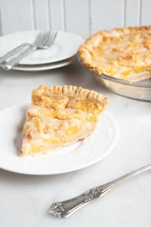 slice of peach pie on a white plate