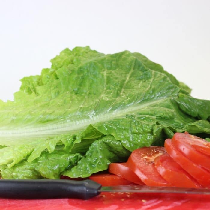 lettuce and tomatoes on cutting boards