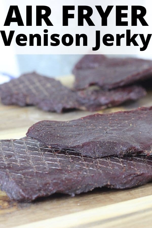 venison jerky sitting on a wooden cutting board 