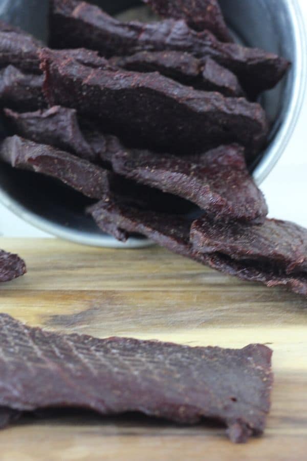 venison jerky falling out of metal bowl and cutting board 