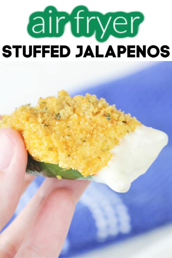 holding a stuffed jalapeno that is dipped in ranch 