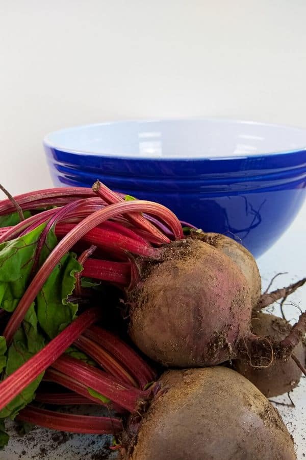 beets on counter with blue bowl behind it 