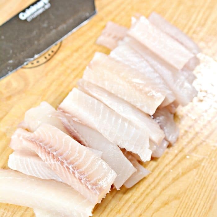 cut up fish on a cutting board 