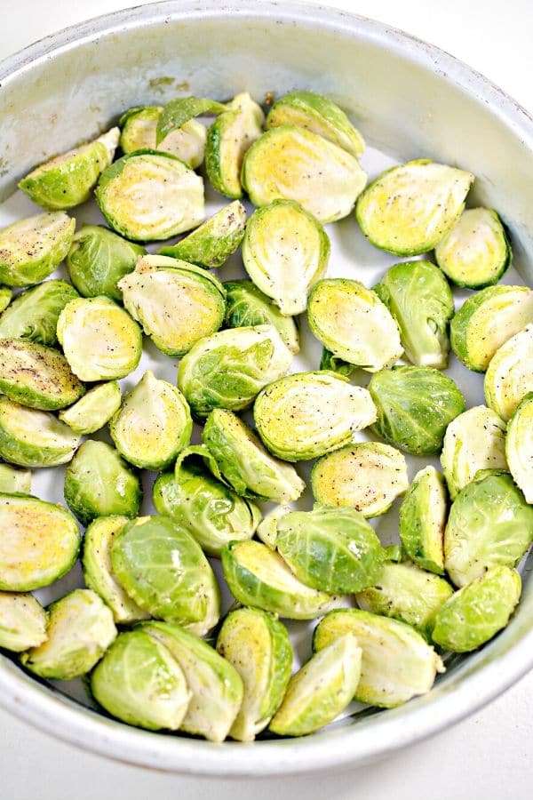 overhead shot of brussel sprouts cut in half in a metal pan 