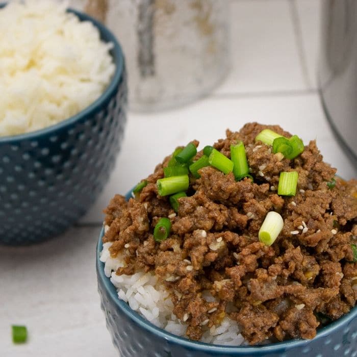 A bowl of Korean beef with rice under it 