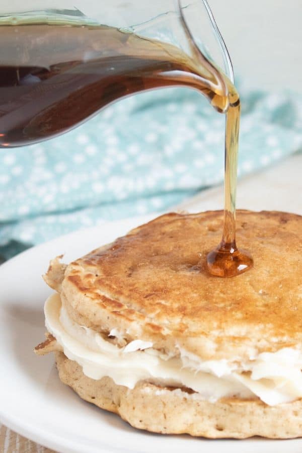 syrup being poured on pancakes