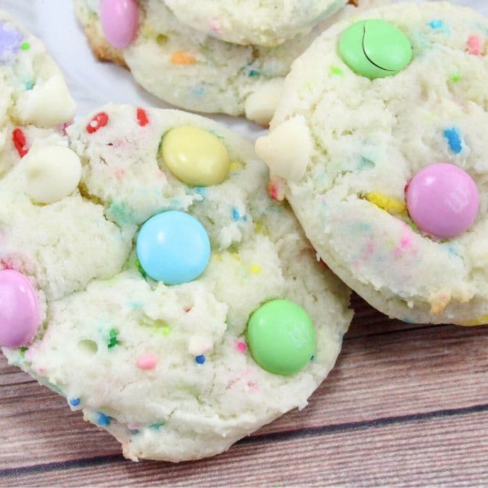 cookies stacked on a wooden table with pastel M&Ms