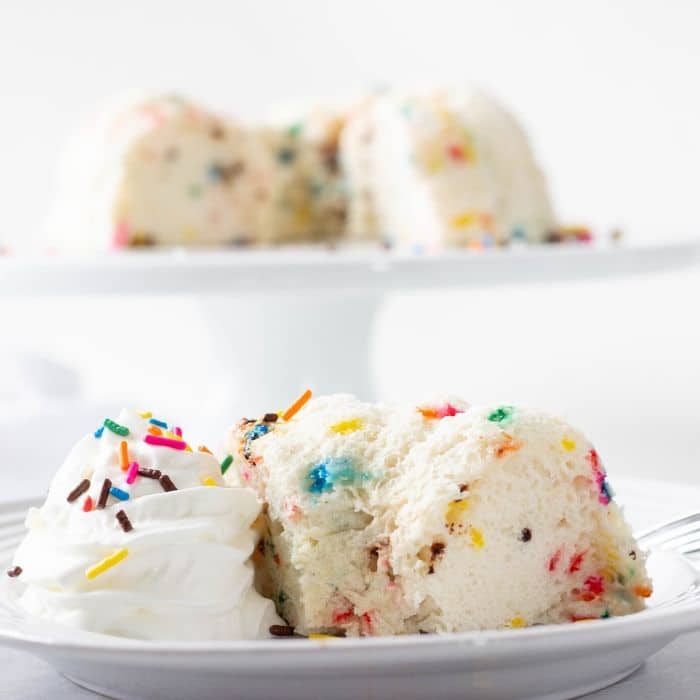 funfetti angel food cake on a plate with whipped cream 