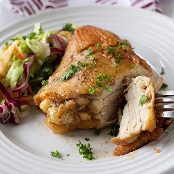 honey garlic chicken thigh on plate with piece cut off