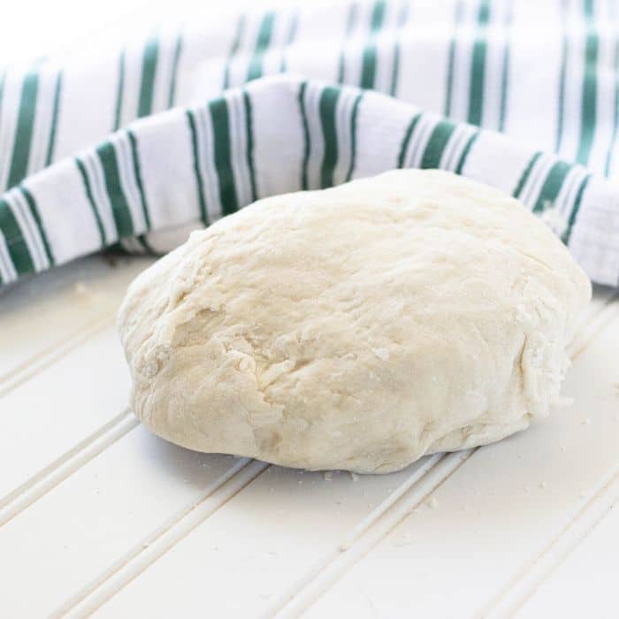 breadstick dough on table with towel behind it