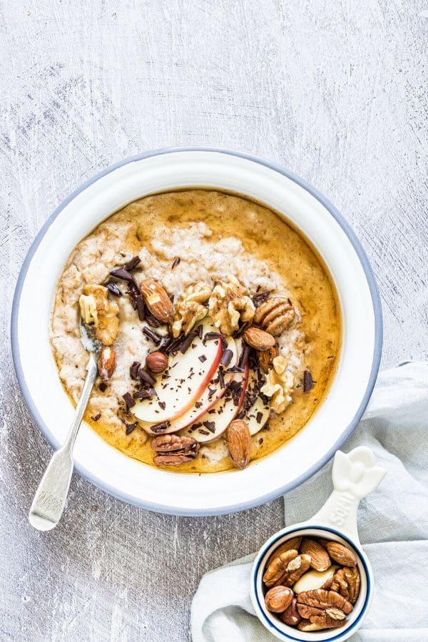 bowl of oatmeal with bowl of nuts by it 