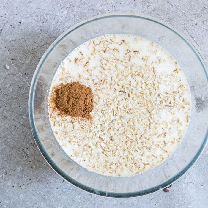 glass bowl of oatmeal, milk, and cinnamon