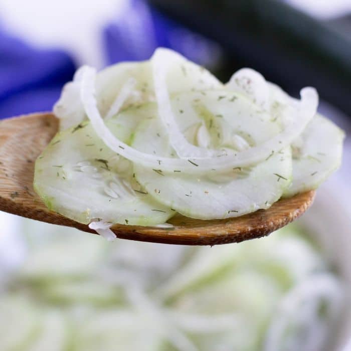 cucumber vinegar salad on a wooden spoon