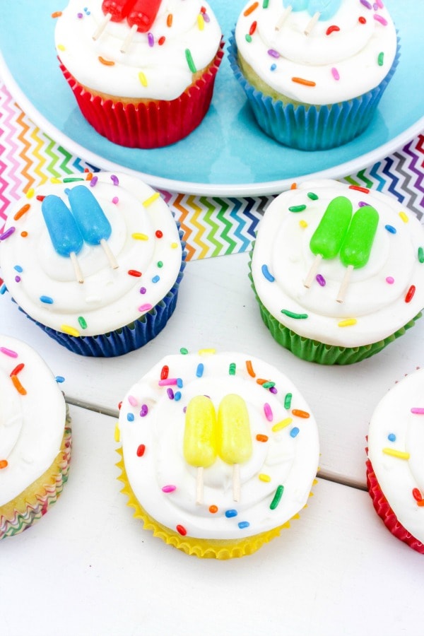 cupcakes on table that are decorated to look like popsicle sticks