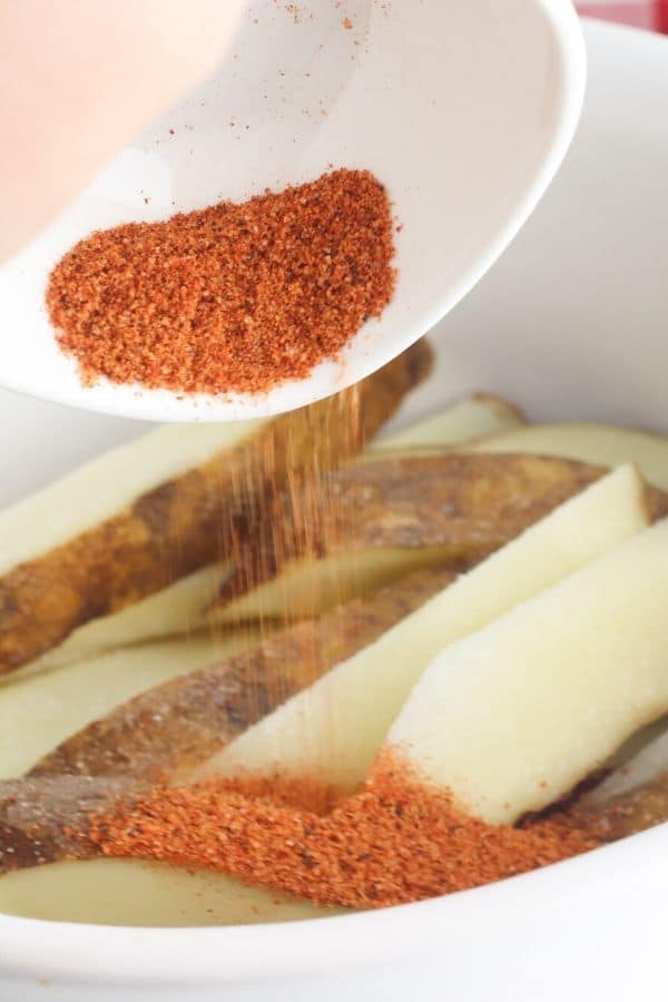 barbeque seasoning pouring onto potatoes 