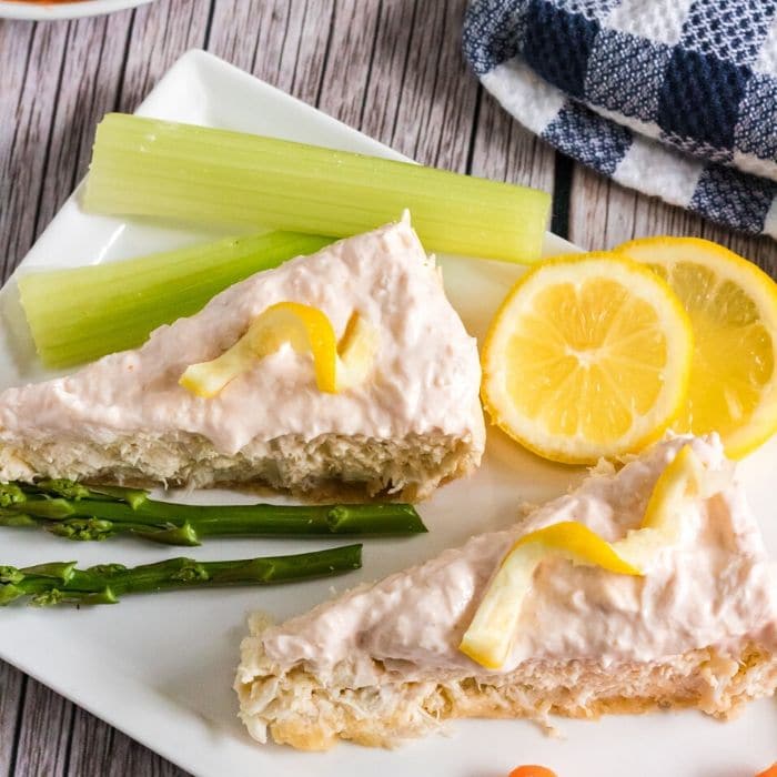 slices of crab cheesecake on platter with vegetables 