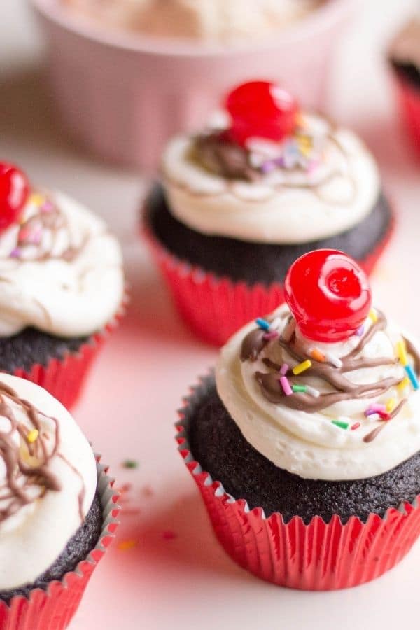 hot fudge sundae decorated cupcakes sitting on table 