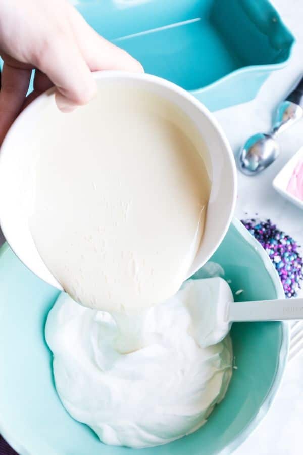 pouring sweetened condensed milk in whipped cream