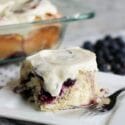 blueberry roll on a plate with berries i the background