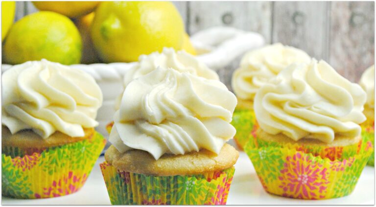 lemon flavored cupcakes on table with bowl of lemons in background 