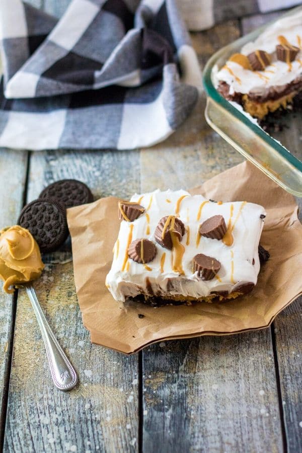 peanut butter lush on table with spoon of peanut butter and Oreos by it 