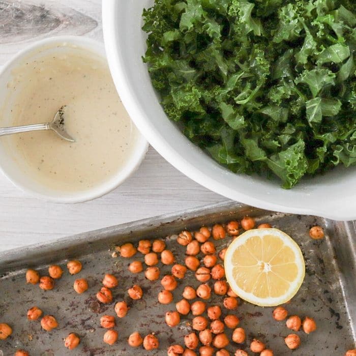 vegan salad dressing in a bowl by kale and roasted chickpeas 