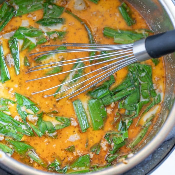 soup with wild ramps and a whisk in Instant Pot 