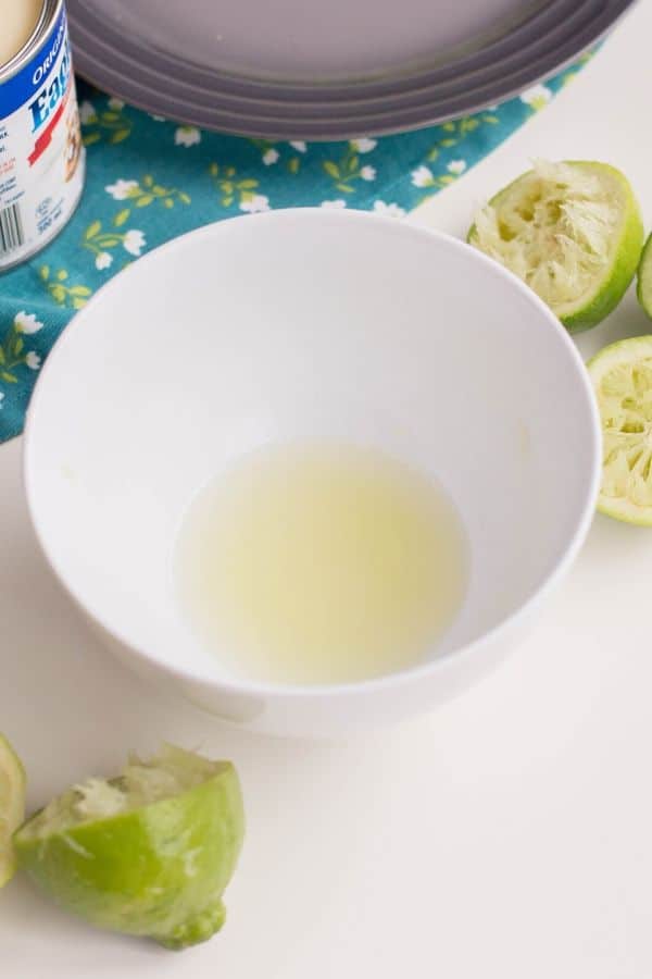 lime juice in a bowl with squeezed limes by it 