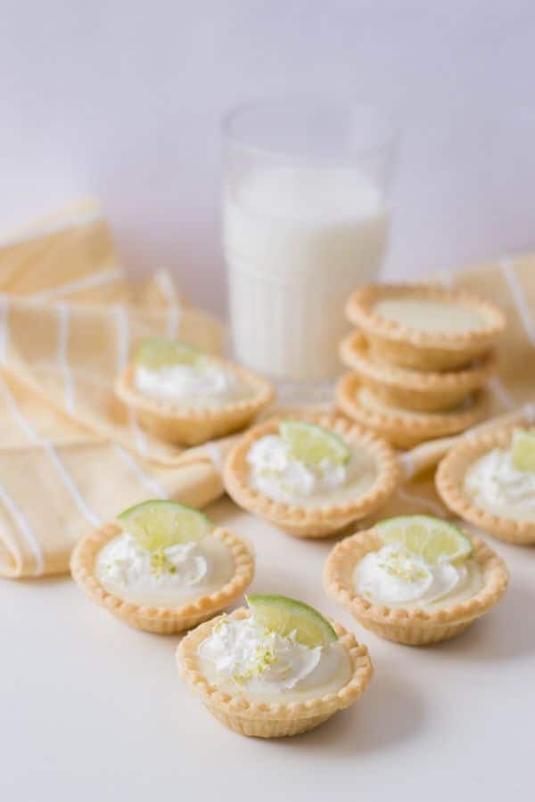 mini key lime pies on a table with glass of milk 