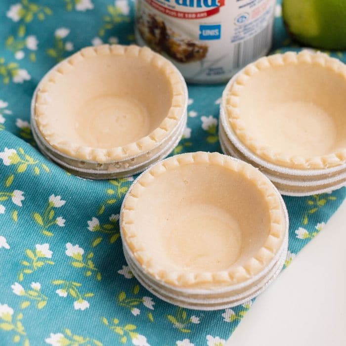 small tartlet crusts  stacked on a table with floral towel