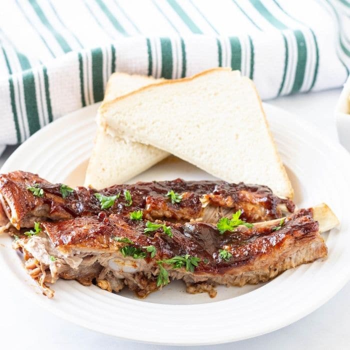 Plate with pork ribs and Texas toast behind it 