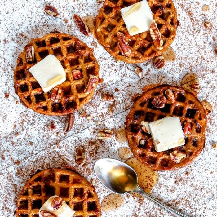 pumpkin chaffles on a table with sugar free syrup and butter 