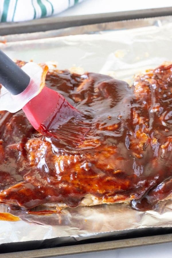 rubbing bbq sauce on pork ribs