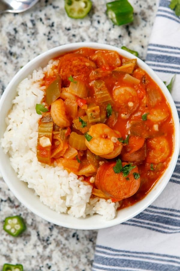 seafood gumbo in a bowl with rice on table 