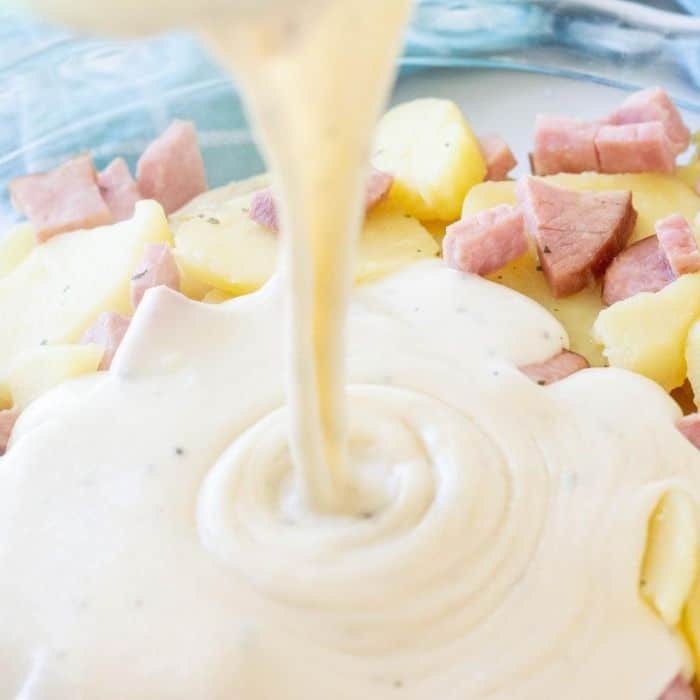 cheesy mixture pouring into pie pan 