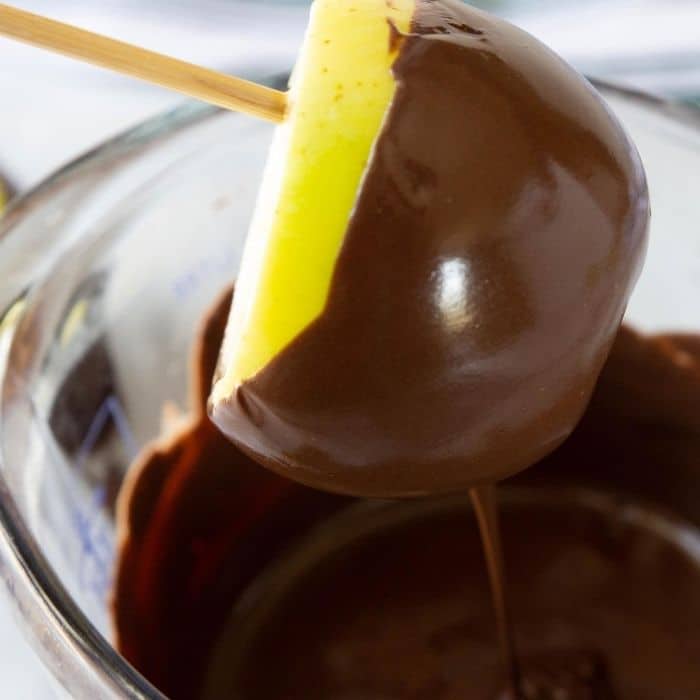 apple dipping in melted chocolate