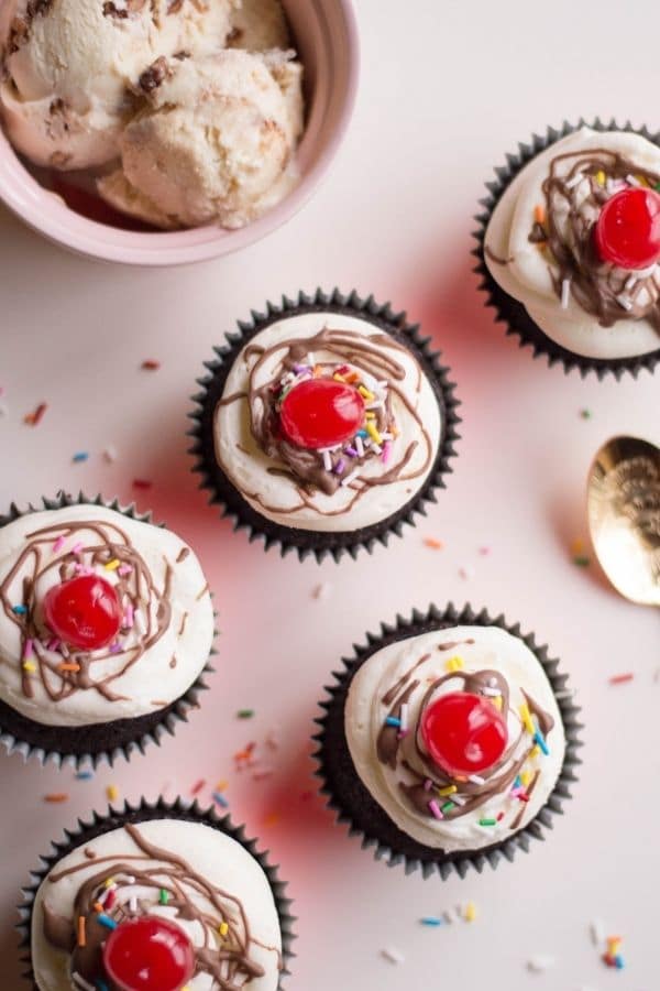 cupcakes for parties on counter with ice cream behind it 