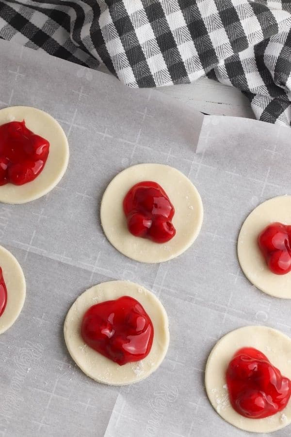 pie crust with cherry pie filling in center 