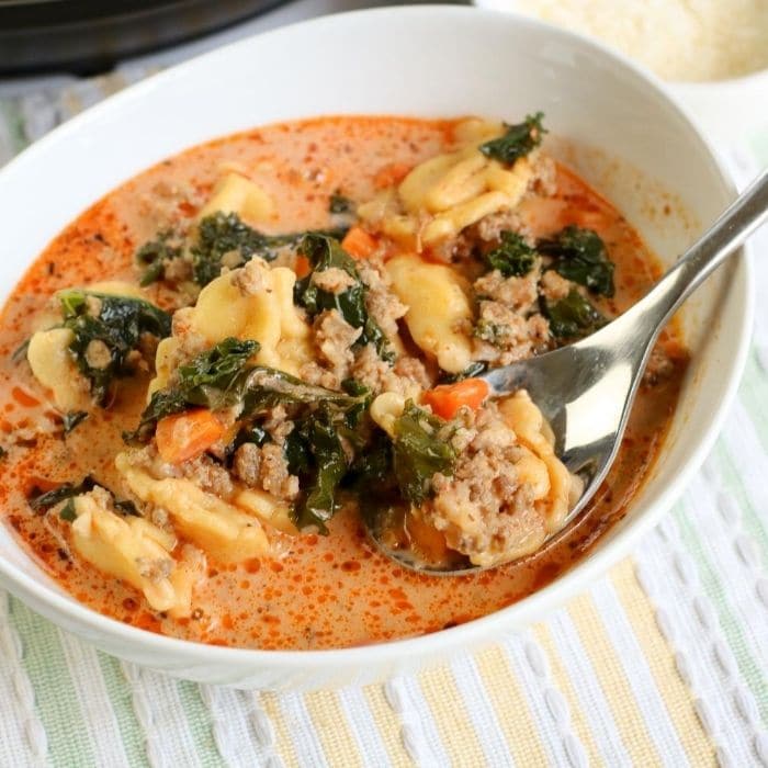 tortellini soup in white bowl with instant pot behind it 