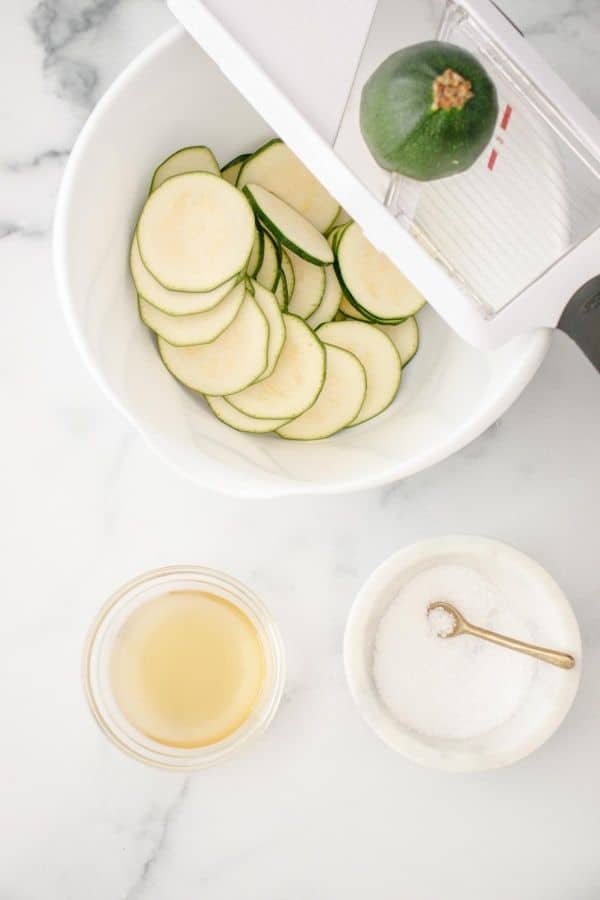 zucchini sliced with mandoline on counter 