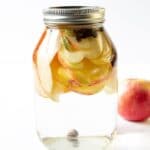 mason jar with vodka and apples and warm fall spices in it