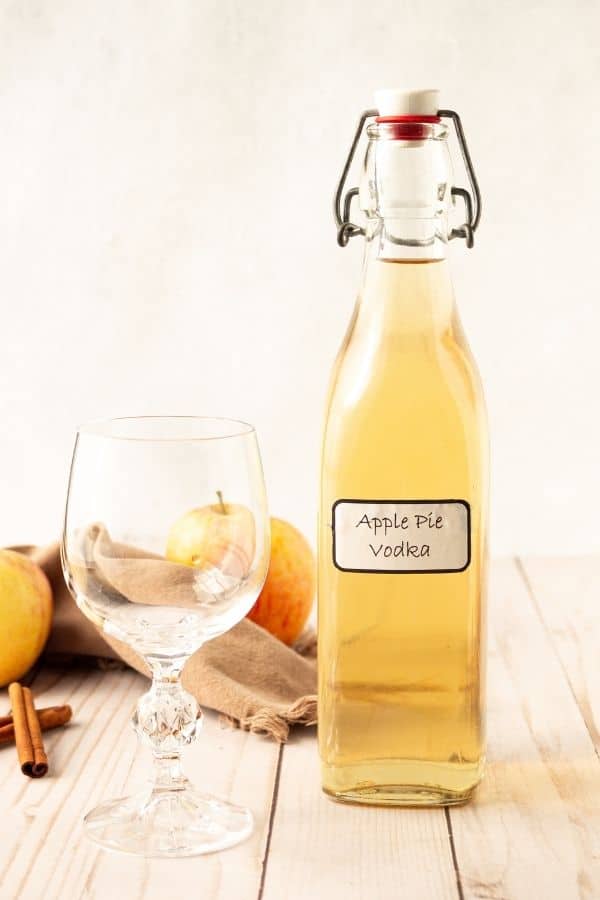 Bottole of apple vodka with wine glass by it 