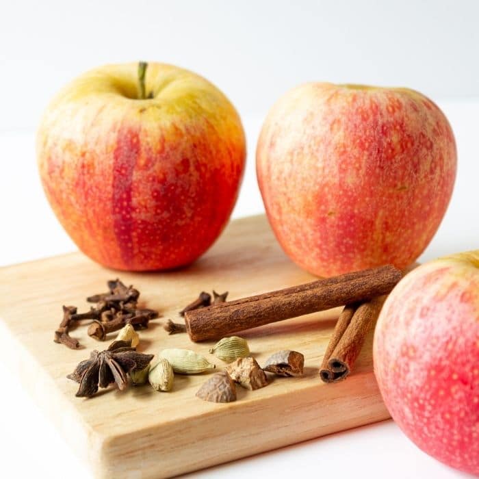apples and spices on a wood cutting board