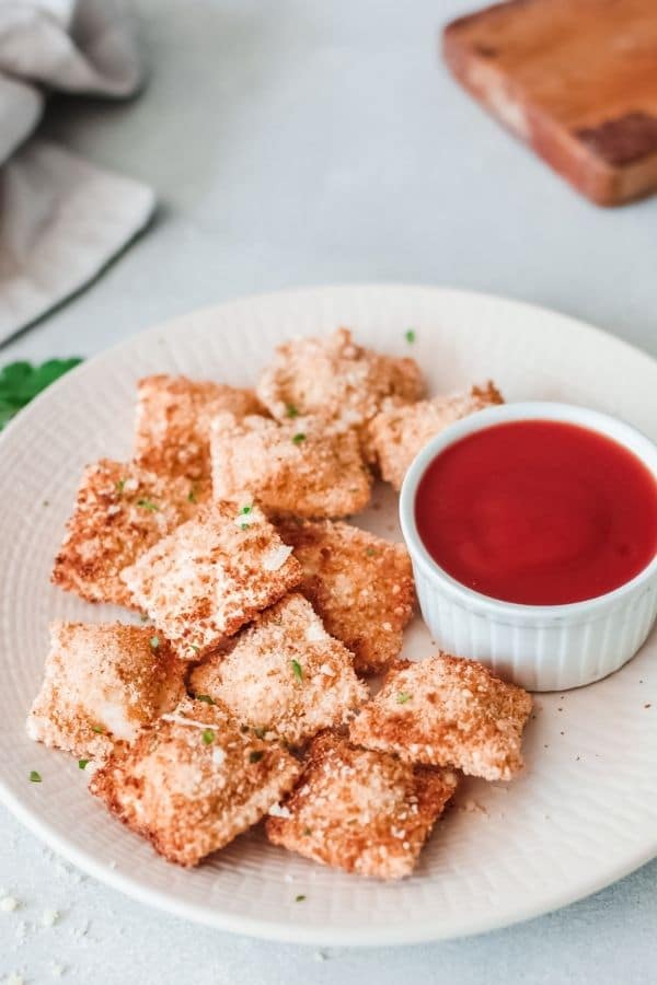 toasted ravioli on plate with tomato sauce