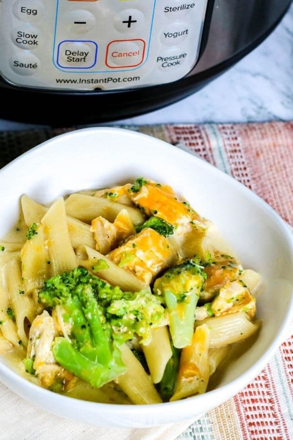 bowl of chicken and pasta with Instant Pot behind it 